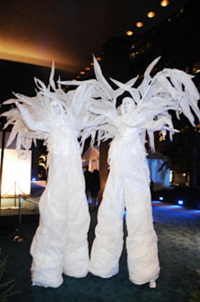 Stiltwalkers spouting feathery fronds marched near the entrance, ushering guests into the party.