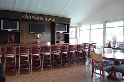 Charles Schwab outfitted its chalet in wood paneling, from the parquet floors to the stool-lined mahogany bar.