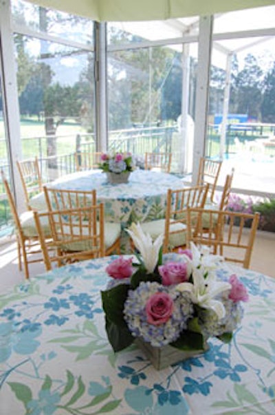 Blue and green floral linens and arrangements of purple roses, white lilies, and blue hydrangea covered the indoor tables at the UBS chalet.