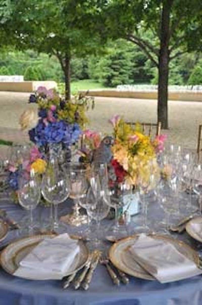 Various vases filled with colorful blooms joined with figurines to create the dinner-table centerpieces.