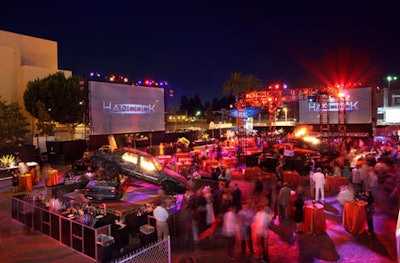 Giant screens lining the perimeter of the after-party broadcast Hancock logos and scenes from the film.