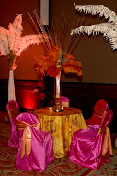 A dazzling feathered centerpiece with a carnival mask and bright accents of orange and raspberry created an elegant twist in the Moroccan lounge area.