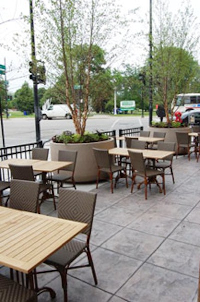An outdoor patio, spruced up with English ivy plants and seasonal flowers, seats 60.