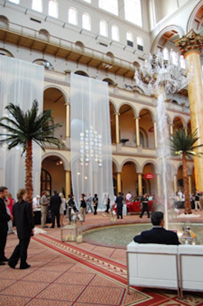 The center space of the National Building Museum offered palm trees, a hanging crystal chandlier, and white leather lounges next to the fountain.