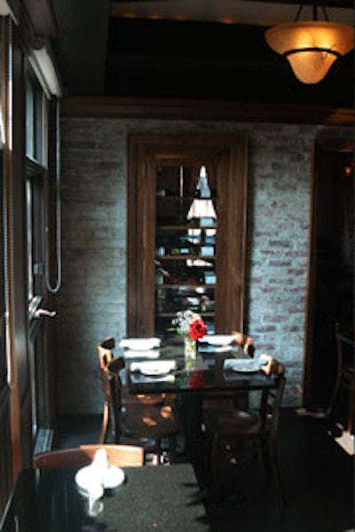Custom-built wine shelves set into the brick walls separate the bar area and the dining room.