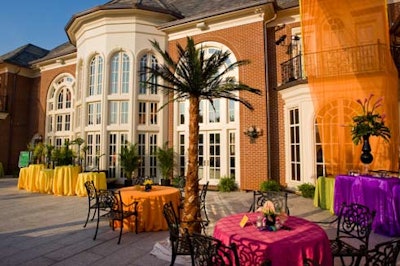 Exquisite Design Studio placed palm trees on the mansion's two-tier marble patio to match the tropical colored linens from Ridgewells.