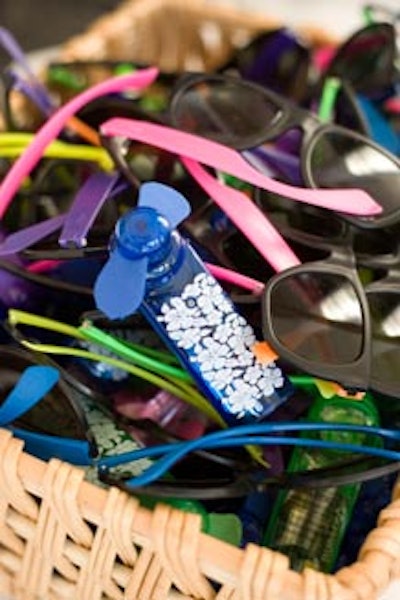 Table decorations included neon sunglasses, battery-operated personal fans, and disposable cameras from CharityWorks.