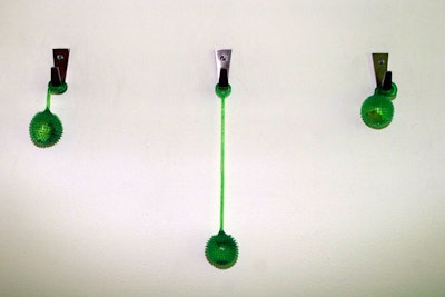 Green toys hung from hooks on the wall, matching the overall color scheme and adding a tactile element to the studio space.