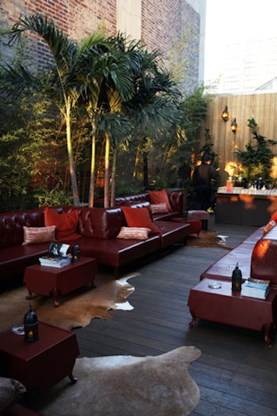 Cow-print rugs, palm trees, red leather couches, and a barbecue characterized the African and Middle Eastern-styled terrace.
