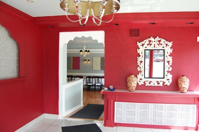 An ornate mirror hangs on the wall in the brightly coloured reception area.