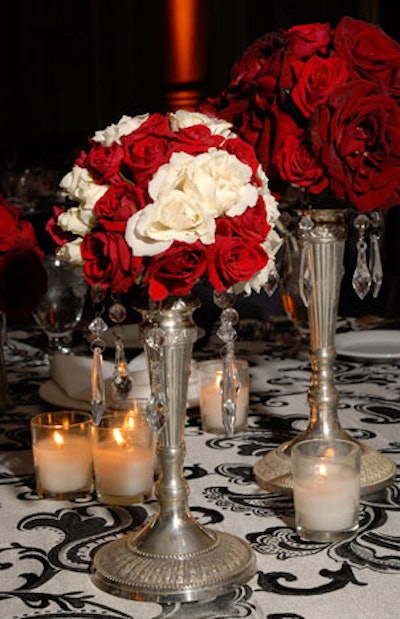 Ivan Carlson & Associates decorated dinner tables with ruby-red and cream-colored roses arranged in silver vases with crystal droplets and a plethora of votives atop silky silver-and-black linens.