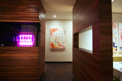 Pink fluorescent lighting illuminates a small wine cellar.
