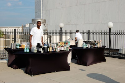 Bars, set on tables with stretched black fabric, ringed the space.