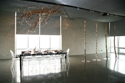 A handmade chandelier—branches decorated with crystals—hung over the dining table. Bare birch trees decorated other areas of the room.