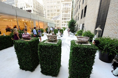 To create a modern garden setting, Elie Tahari covered its fifth-floor roof space with white Astroturf and boxwood hedges.