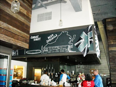 A large chalkboard above the 50 seat bar area shows the day's specials.