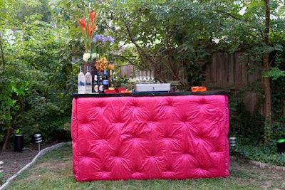 Three neon pink tufted bars featuring cocktails from SurReal Vodka ringed the yard.