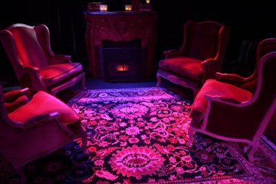 The carpeted stage area featured velvet chairs and an antique carpet in front of a faux fireplace.