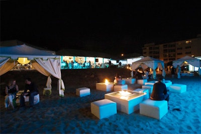 Seating surrounded fire pits on the sand.