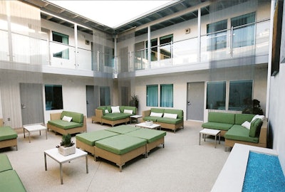 The hotel's courtyard features modern-looking cushioned seating.