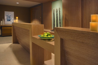 Spa attachés meet guests in the facility's lobby, which is decorated in earth tones and natural materials.