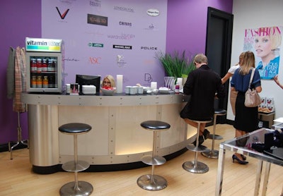 Logos from featured brands and sponsors in the Wardrobe Lounge served as a backdrop to the bar area.