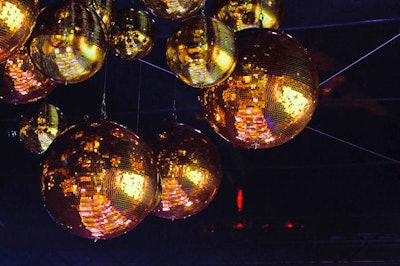 The party's decor included gold disco balls of various sizes.