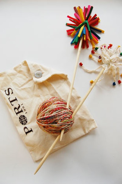 The gift bag at the Ports 1961 show was a branded pouch filled with two knitting needles, a ball of multicolored yarn, and knitting instructions.