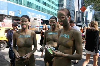 Models covered in clay handed out samples from cosmetics company Ahava.