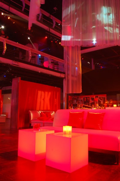 White leather couches, ottomans, and tufted benches and glowing cube tables made up the mini lounge areas.