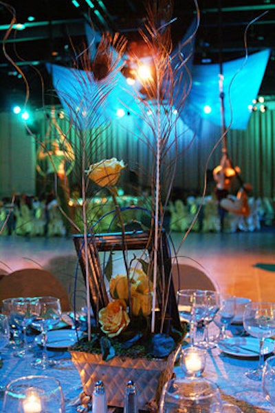 Simple centerpieces of peacock feathers were designed to keep guests focused on the main attraction: live acrobatic dancers.