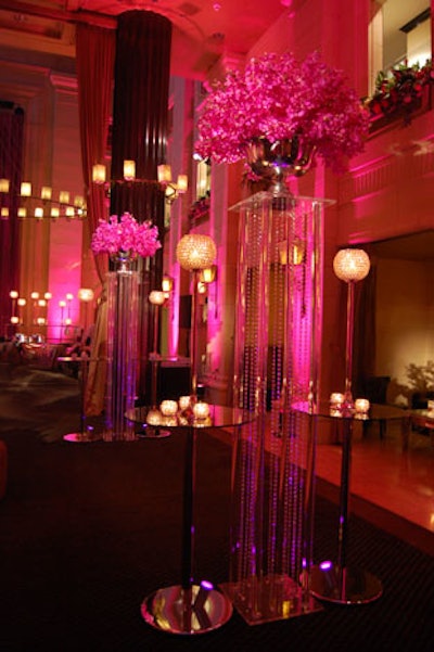Silver vases filled with pink orchids topped tall columns featuring crystal beading.