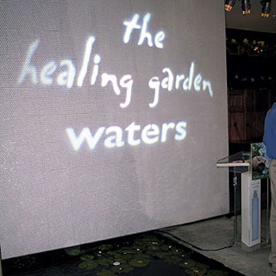 A gobo light with the Healing Garden Waters logo shone above a small pond in the floor of the Bloom store.