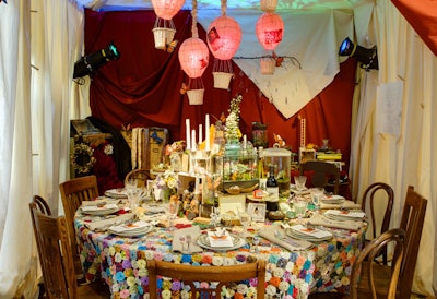 A patchwork quilt-like tablecloth topped Soolip and Floracopia's table, along with an assortment of knick-knacks like buttons, feathers, and Russian dolls.