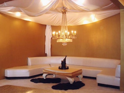 A golden chandelier illuminates gold-speckled walls.