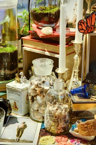 Designer Constantine Del Rosario filled jars with an assortment of small shells and included them among the toys, photographs, and other trinkets strewn across Soolip Floracopia's tabletop.