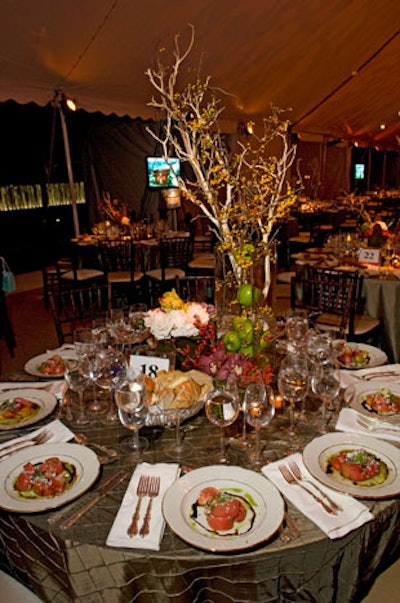 Kehoe Designs created centerpieces of branches and apples and set them on sage green linens for each dinner table.