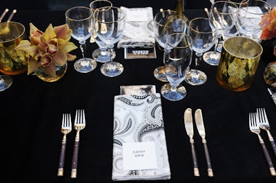 Black linens and paisley napkins topped tables for an understated decor look appropriate to sponsor Gucci.