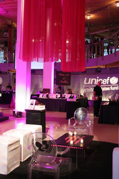 Two lounge environments featuring white couches, acrylic chairs, and low-slung coffee tables filled the first floor along with silent auction displays.