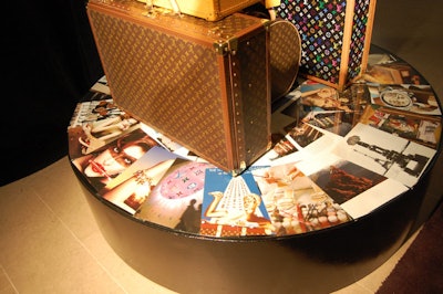 The base of the Louis Vuitton luggage tower displayed photos and advertisements from the brand.