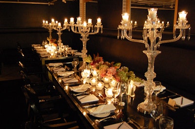 Crystal chandeliers and long floral arrangements in mirrored vases topped tables in the dining area.