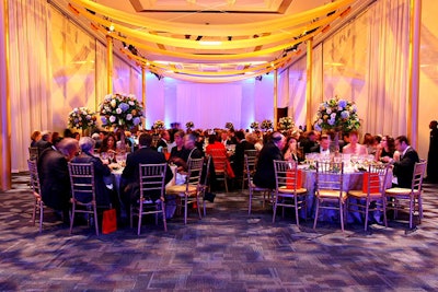 Floral arrangements presented in gilded vases evoked a regal look for the benefit's dinner.