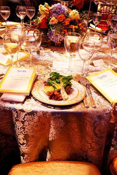 The evening's dinner included field greens and lamb osso buco, and blue and gold linens topped the tables.