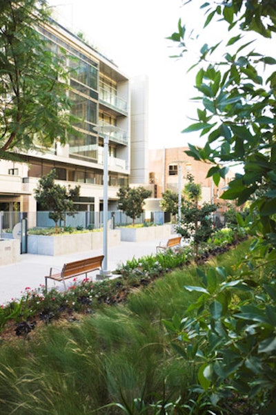 Adjacent park space features benches and landscaped gardens.