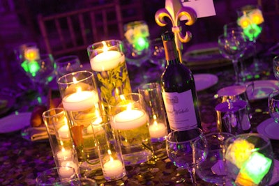 Arrangements of clear vases of various heights filled with floating flowers and candles topped each of the tables.