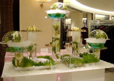 2Taste Catering created a greenhouse-esque display with globe-shaped vases, grass, orchids, and dry ice for added effect.