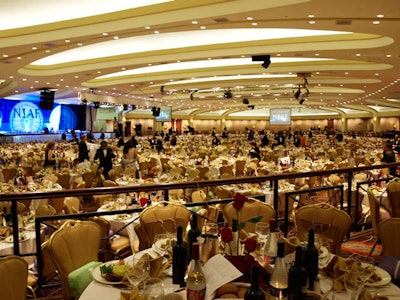 Tabletops featured bottles of Italian wine, olive oil, and specialty water, along with bouquets of red roses.