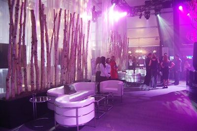 Birch tree branches line the entrance to the all-white V.I.P. lounge designed by Nicholas Pinney of Nicholas Pinney Design.