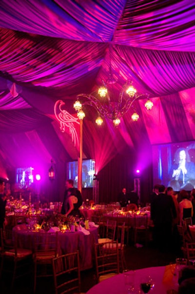 Custom touches included four eight-foot-wide wrought-iron lantern chandeliers suspended from the ceiling in the dining tent, above a painted dance floor featuring a magenta, eggplant, and gold mosaic pattern.