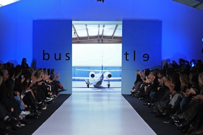 Bustle designers Shawn Hewson and Ruth Promislow used a self-supporting backdrop with an image of a private jet in an airplane hanger for the presentation of their menswear collection.